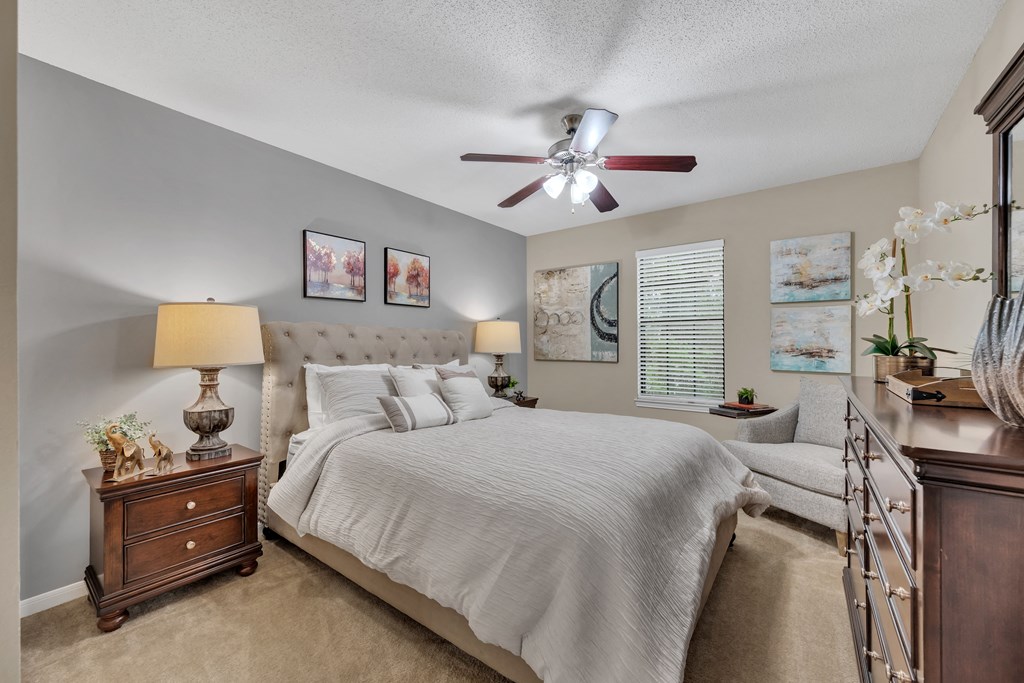 a bedroom with a bed and a ceiling fan